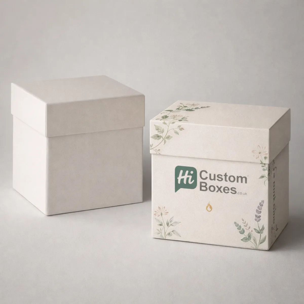 Two elegant square gift boxes with floral illustrations, one plain and one featuring custom branding. class=